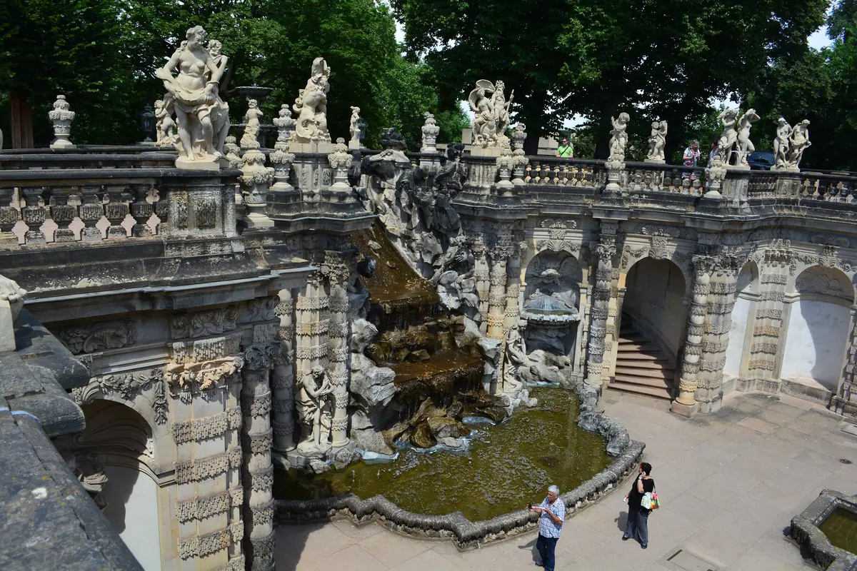 The Nymphs' Bath of the Zwinger, a stone grotto with stairs, a cascade and white sculptures along the balustrade.